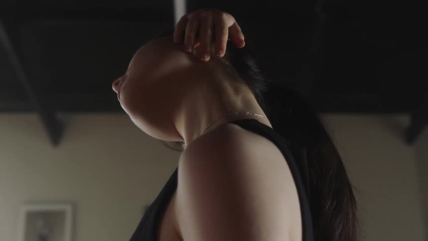 A latina lady on a black training top performing a stretch