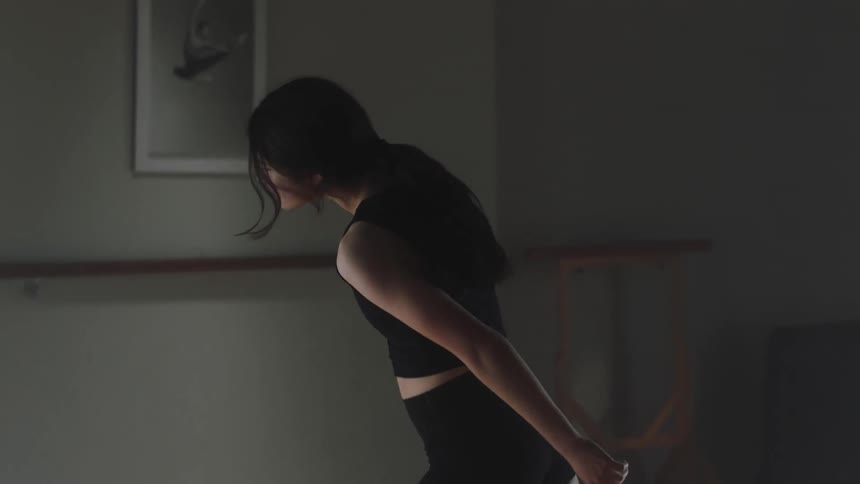A young girl engaging in yoga gracefully spinning her body and hands around in a fluid motion