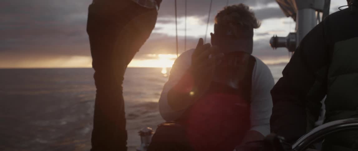 A man is sitting on a boat at dawn
