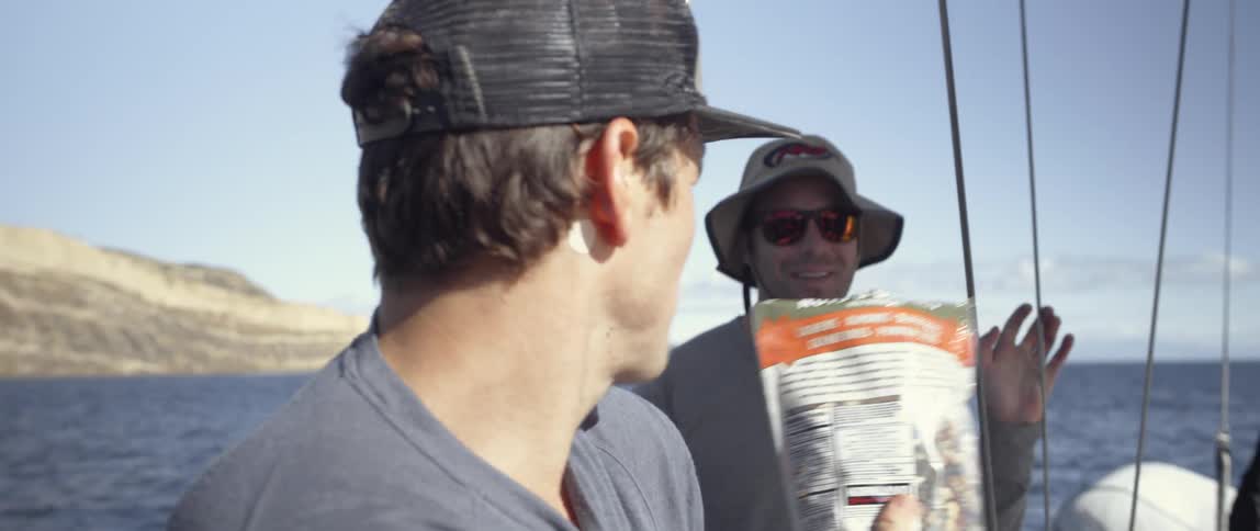 Men share snacks on a boat