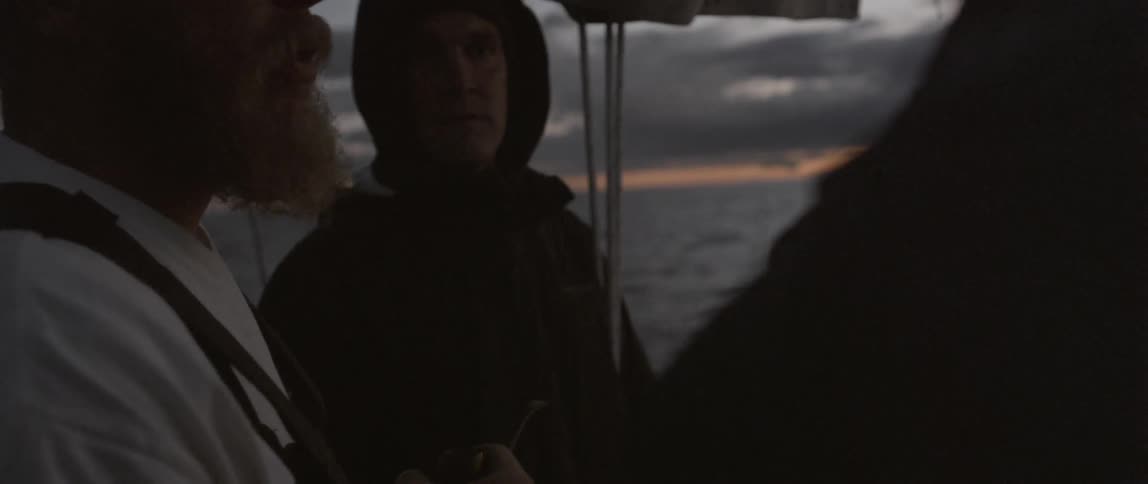 Men are on a boat talking at sunset