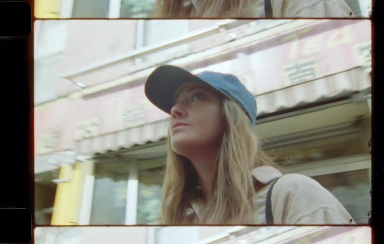 Woman wearing a cap walking between buildings in a street during day time