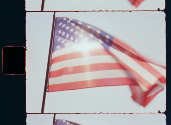 Retro Super 8 close-up of the American Stars and Stripes flag that waves and sways in the breeze on a sunny day during a patriotic Independence Day celebration by proud Americans