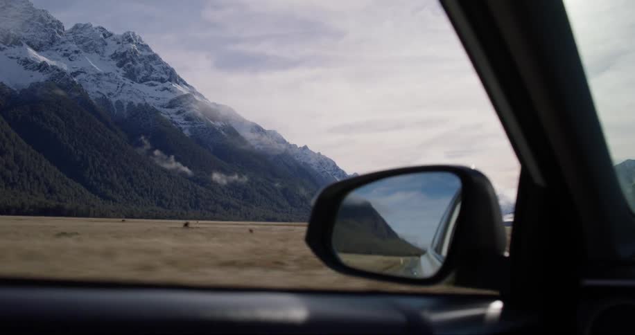 Snow capped mountains as seen from a moving car