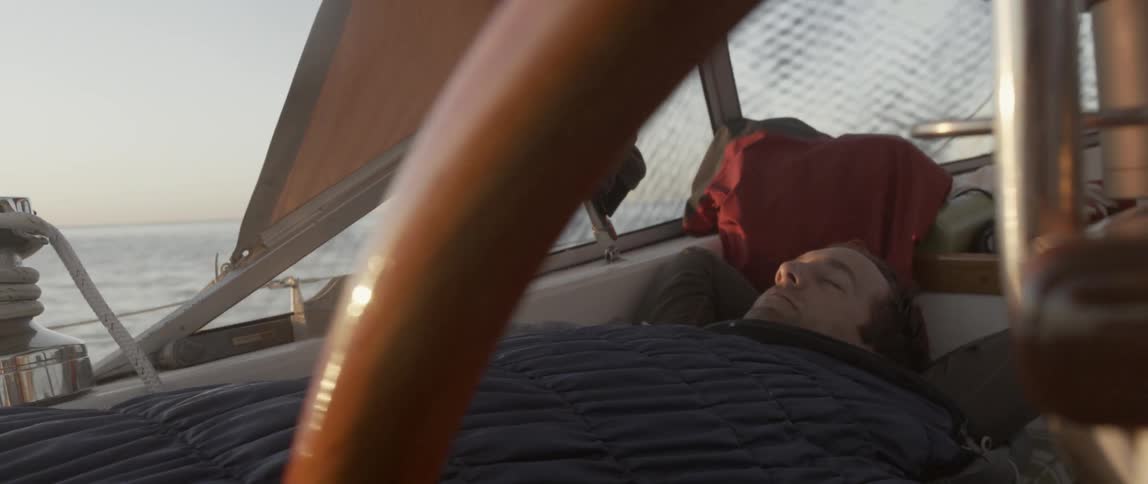 A man is laying down in a boat