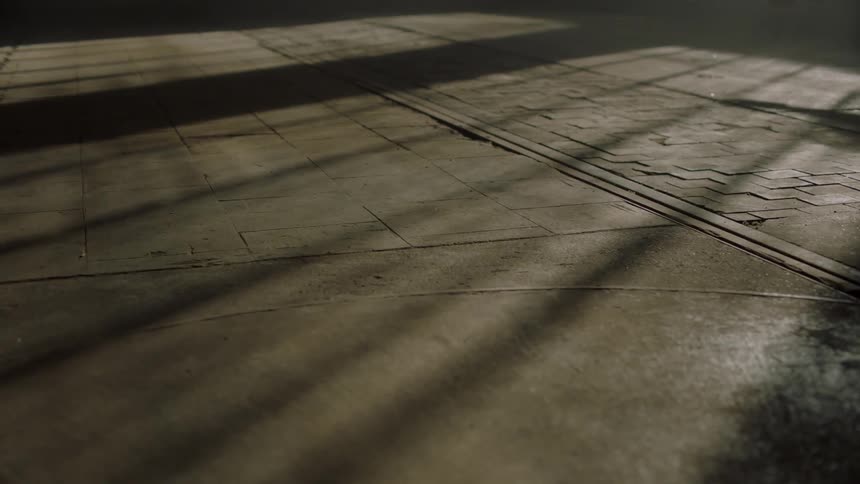 A woman dancing ballet in a skirt in a dark room with sunlight coming in through the windows