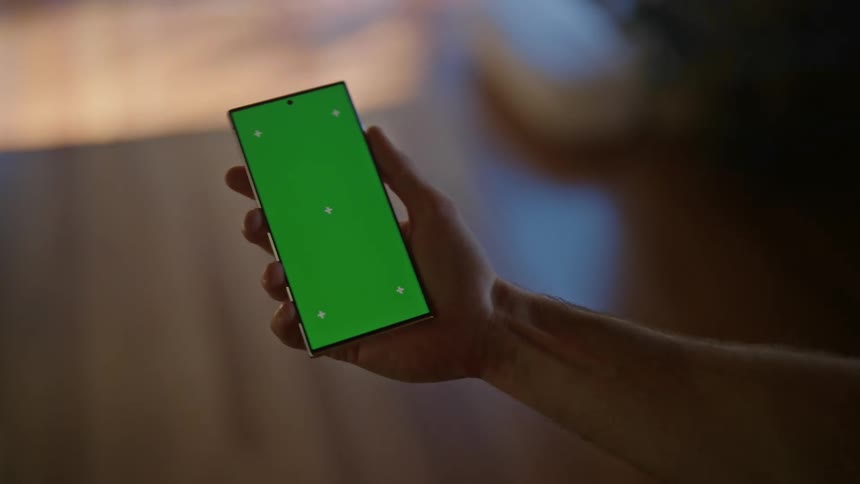 Person walking indoor with a mobile phone placed in the palm