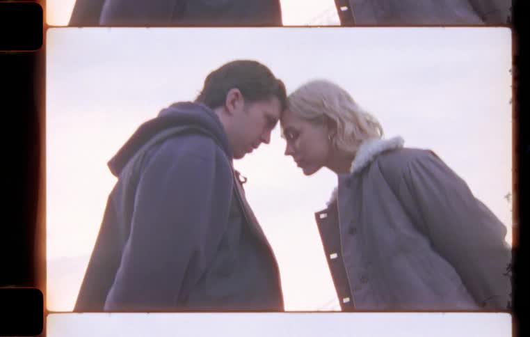 A man and a woman look at each other and put their heads together