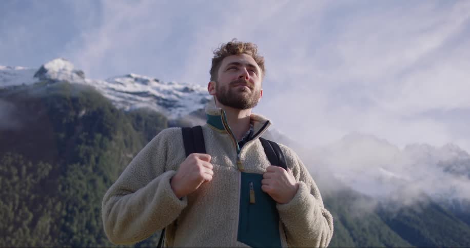 Man stands in a mountain area contemplating