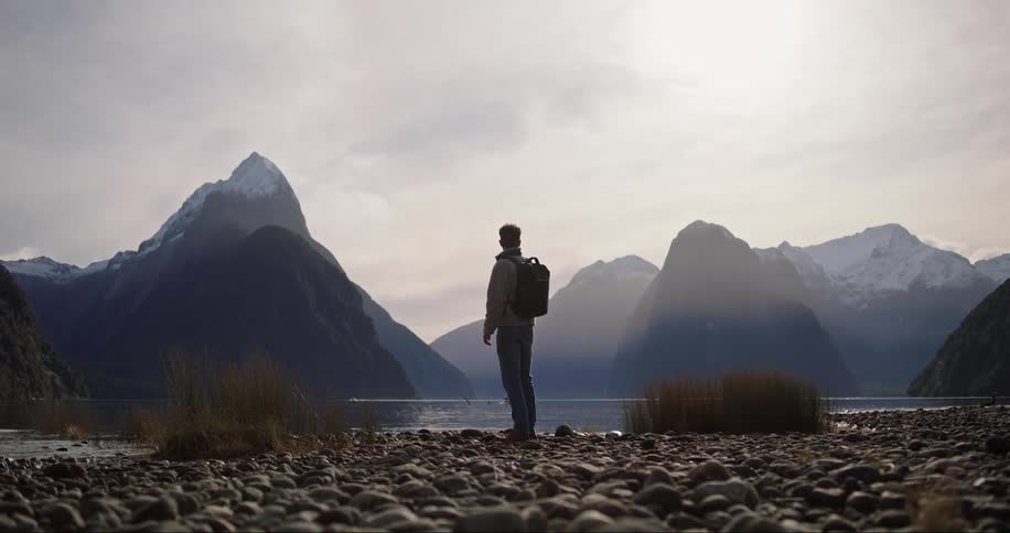 An explorer standing and contemplating by the river bank