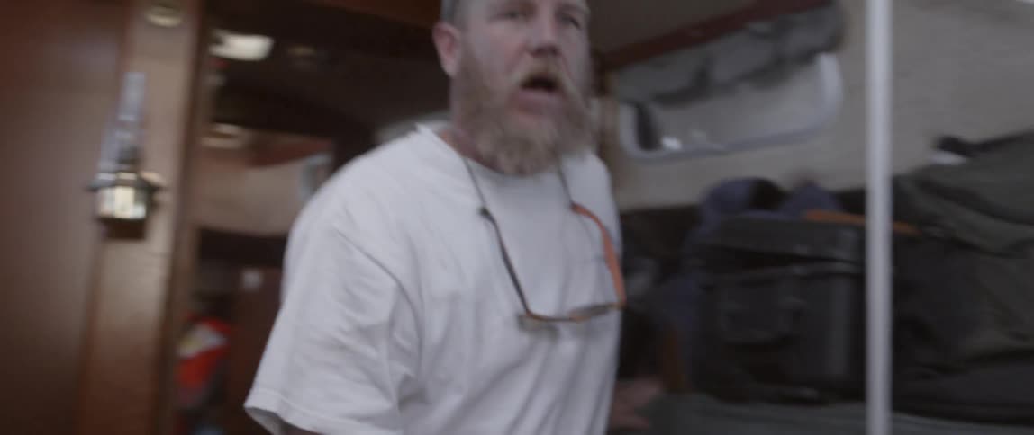 A man walks through a doorway talking