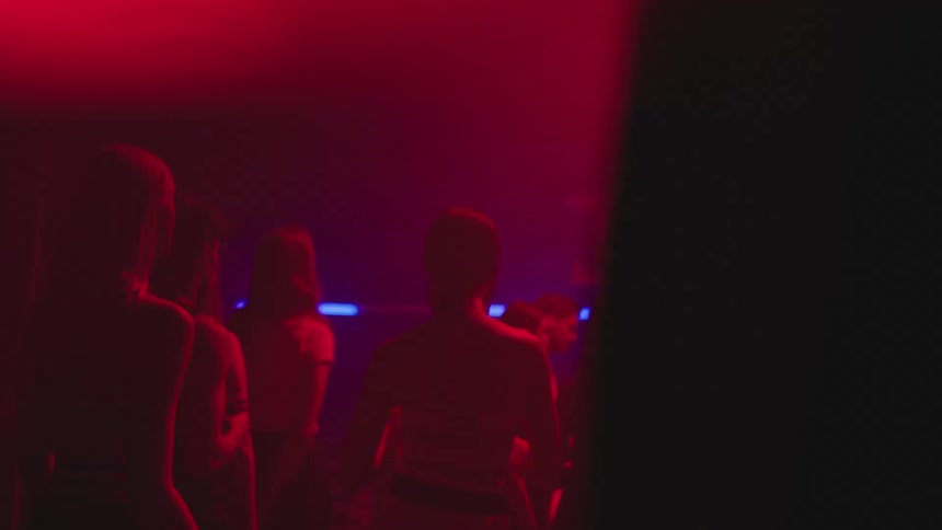 People dancing in an indoor environment with red and blue lights