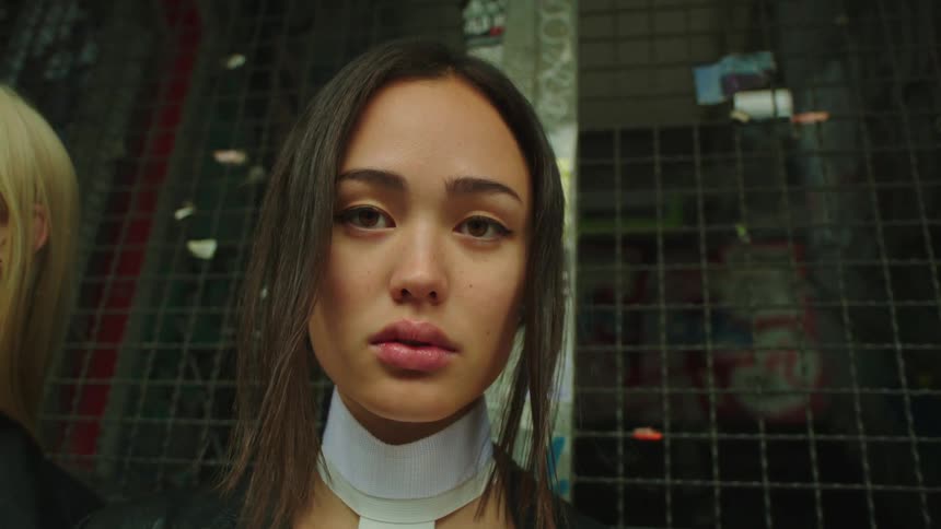 A woman staring directly at the camera posing expressionlessly
