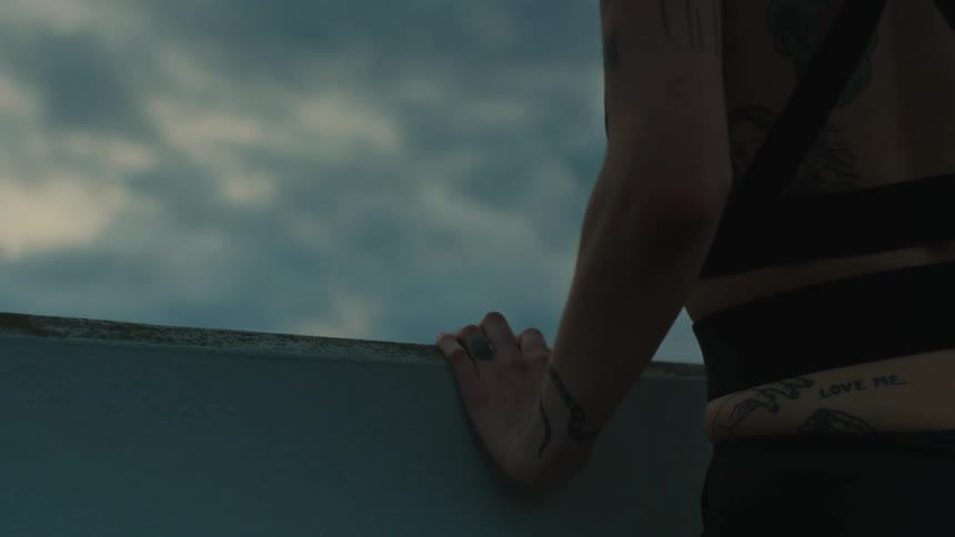 A woman on a balcony before sunrise