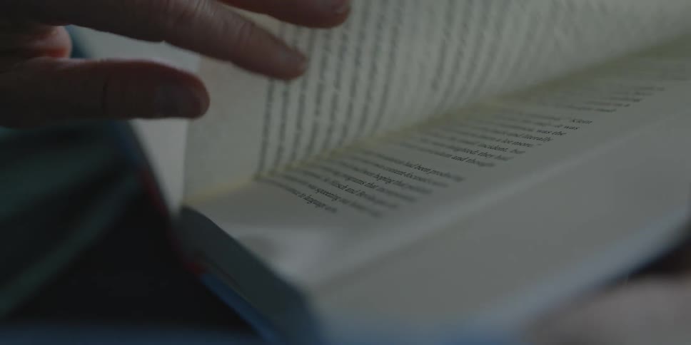 Closeup of a hand turning the pages of a book