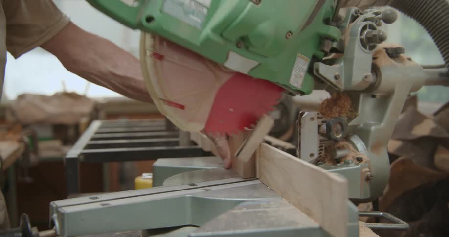 A man using a large circular saw to cut wood