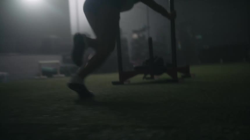 People running and pushing a weightlifting platform simultaneously
