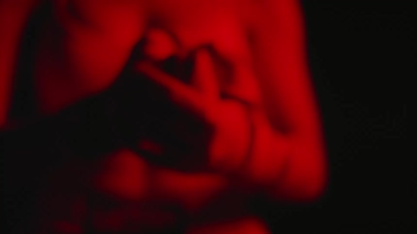 Hands of a female boxer stretching her fingers under red lights