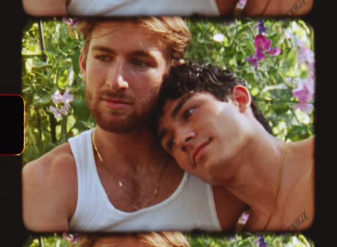 Man put head on the shoulder of another man in a garden at midday