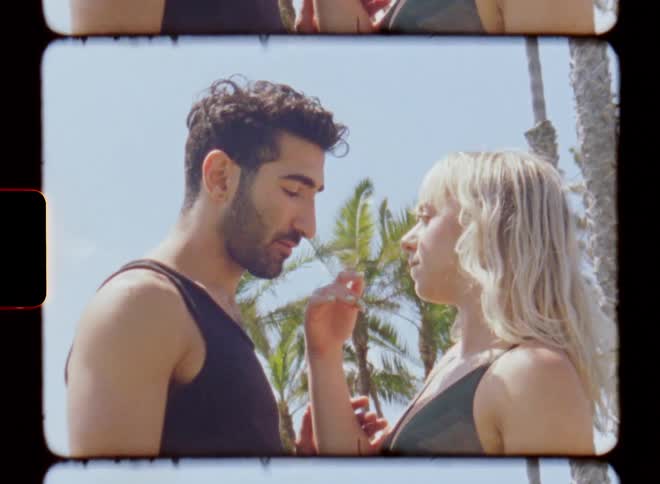 A man and a woman looking at each other romantically until the woman runs her hand over the mans face