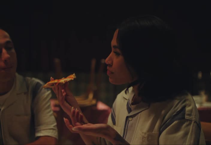 People sitting at a table eating pizza chatting and joyful