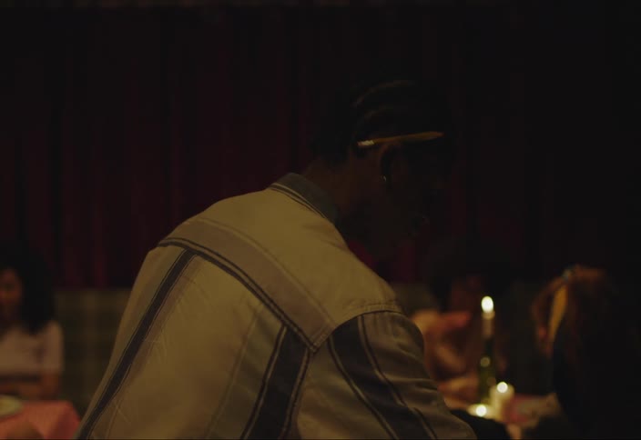 Black waiter at a restaurant serving a pizza then pouring wine and walking around the room serving tables