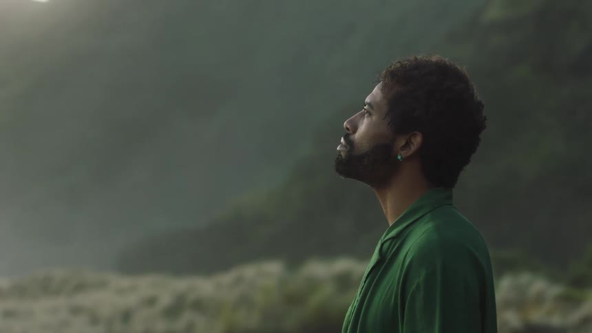 A man standing in a field taking a deep breath to compose himself