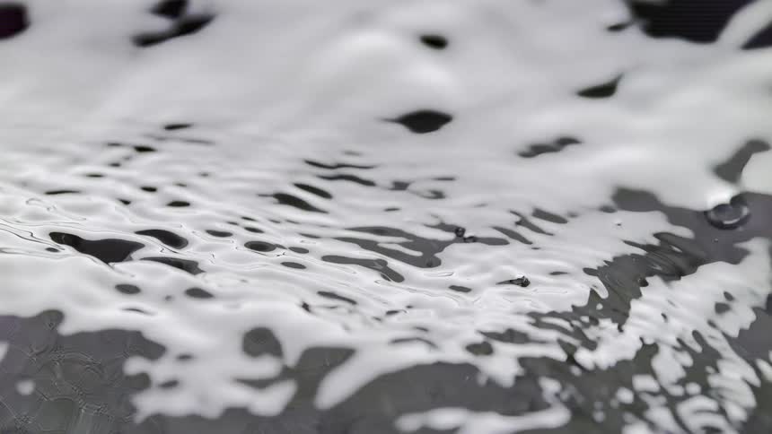 A liquid with small ripples moving over its surface