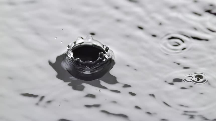 Large water drops create ripples on liquid surface