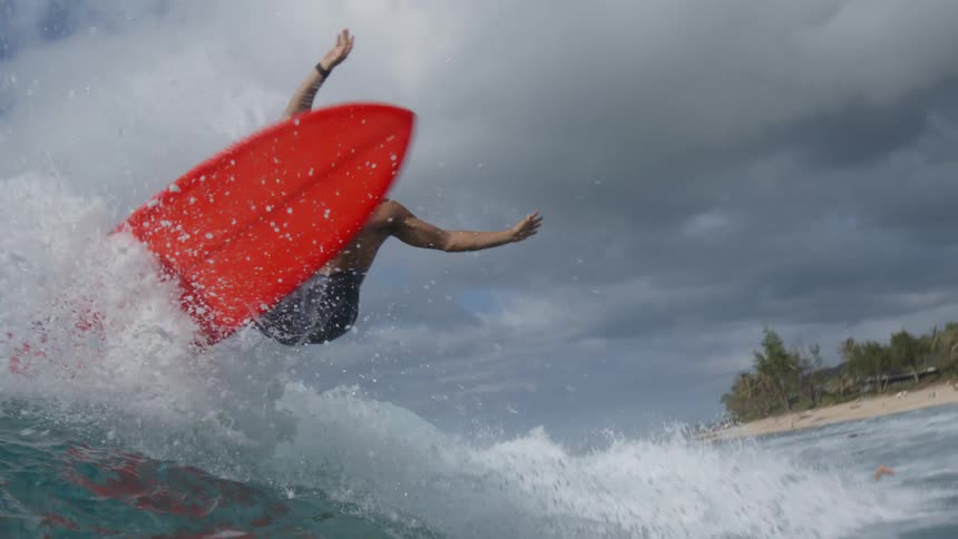 Man surfs ocean waves on cloudy day