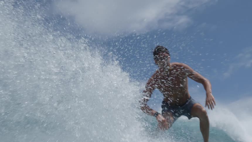 A man on top of a surfboard riding a wave