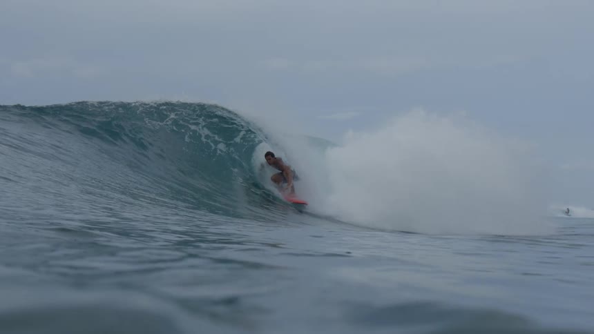 A shirtless man riding a wave in the sea