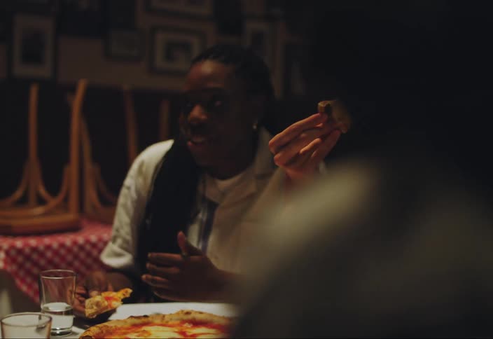 Friends are talking and eating pizza in an empty restaurant