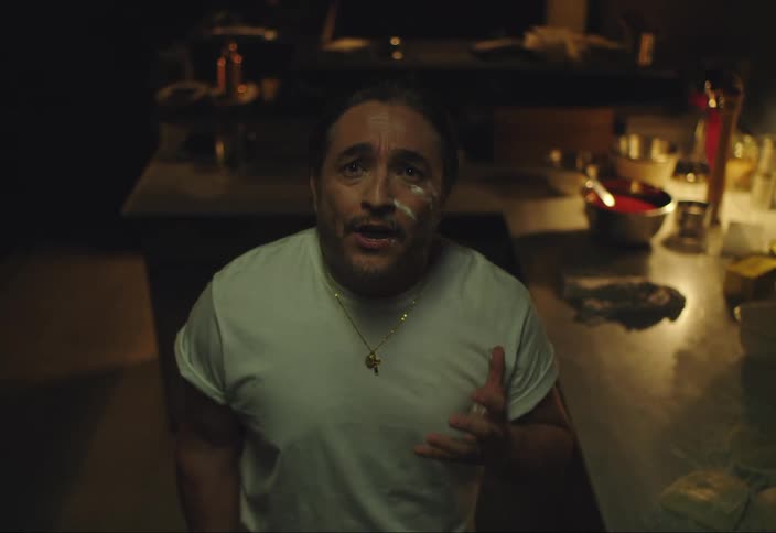 A man sings in a dark kitchen