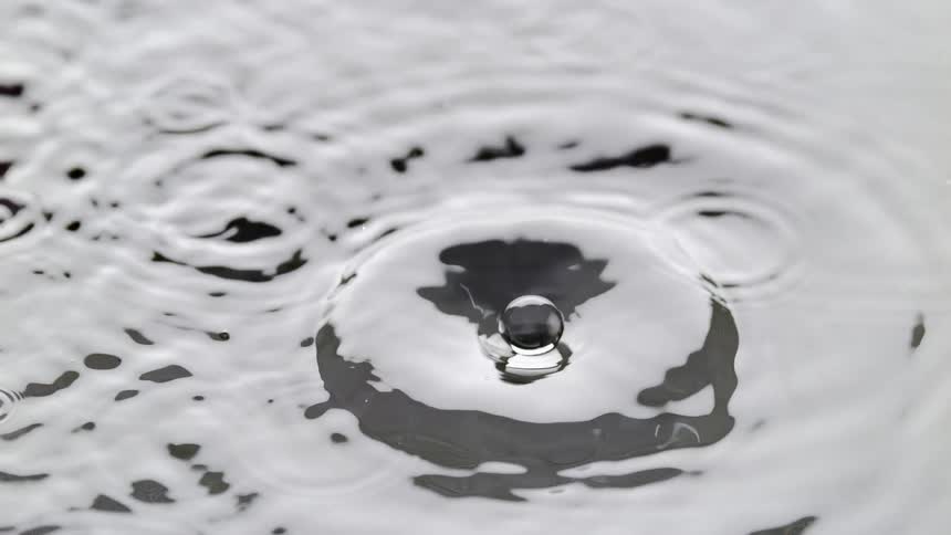 Drop fall on a clear puddle splashing