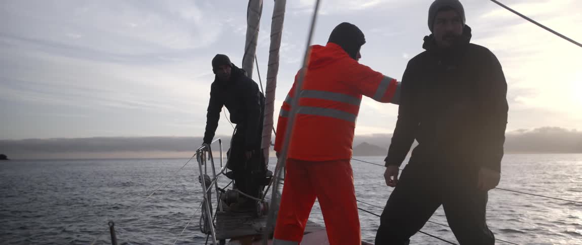 Three people are on the end of a boat together