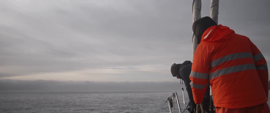 Two people are using rope on a boat