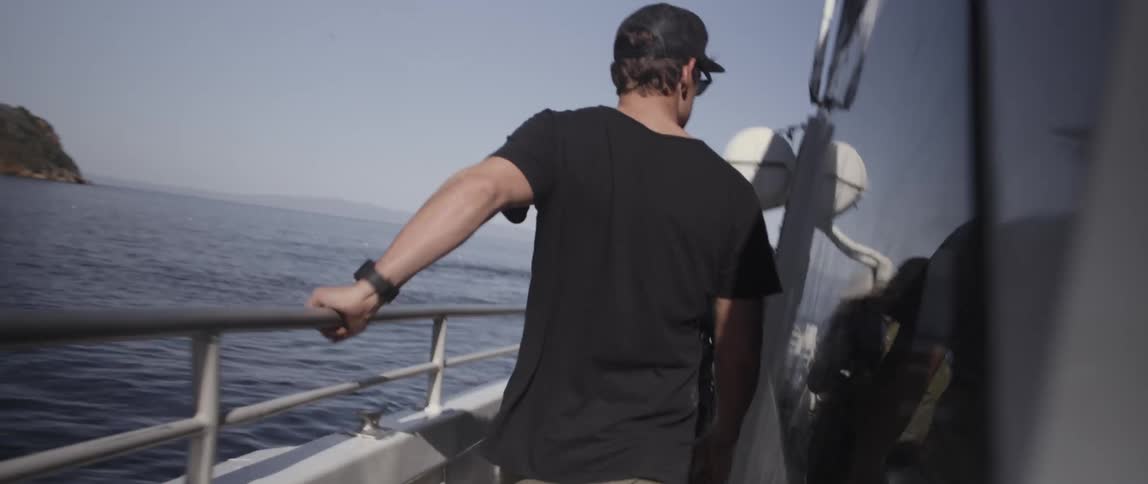 People walk along the side of a boat