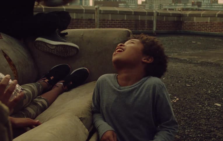 Children sitting on the couch and another on the floor chatting happily amongst themselves