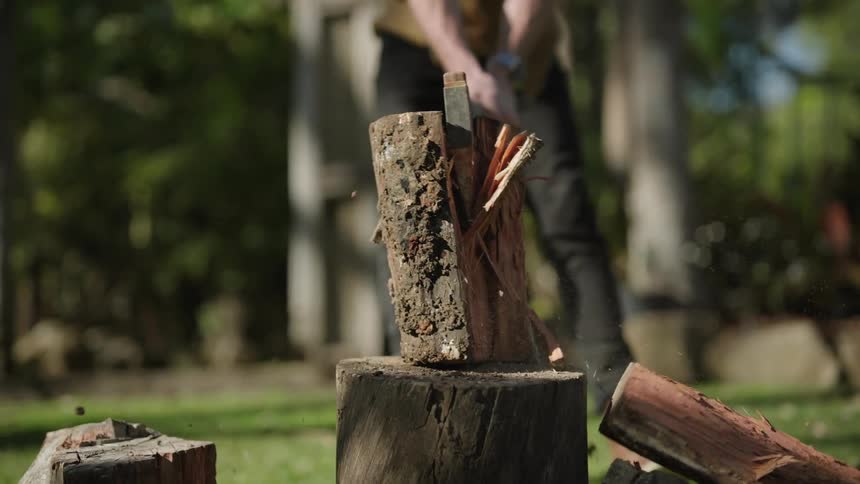 Man splits a log with an ax