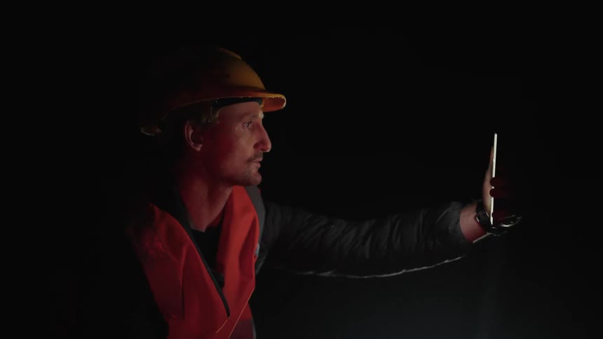 Worker wearing safety gear on a phone call at night