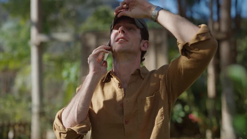 A man stands outside talking on his phone