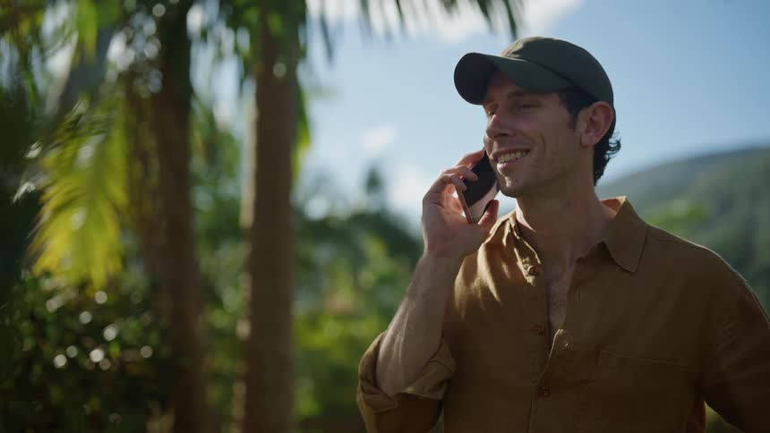 A man is talking on his cell phone in a natural setting