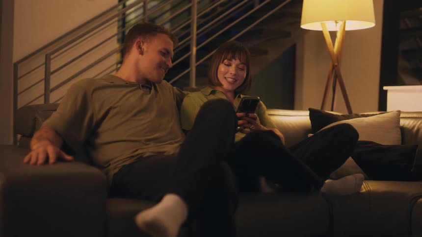 A woman walks over to the couch and sits down to talk