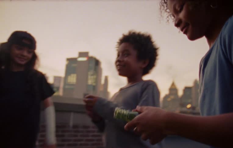 Three children on the terrace of a building playing and smiling