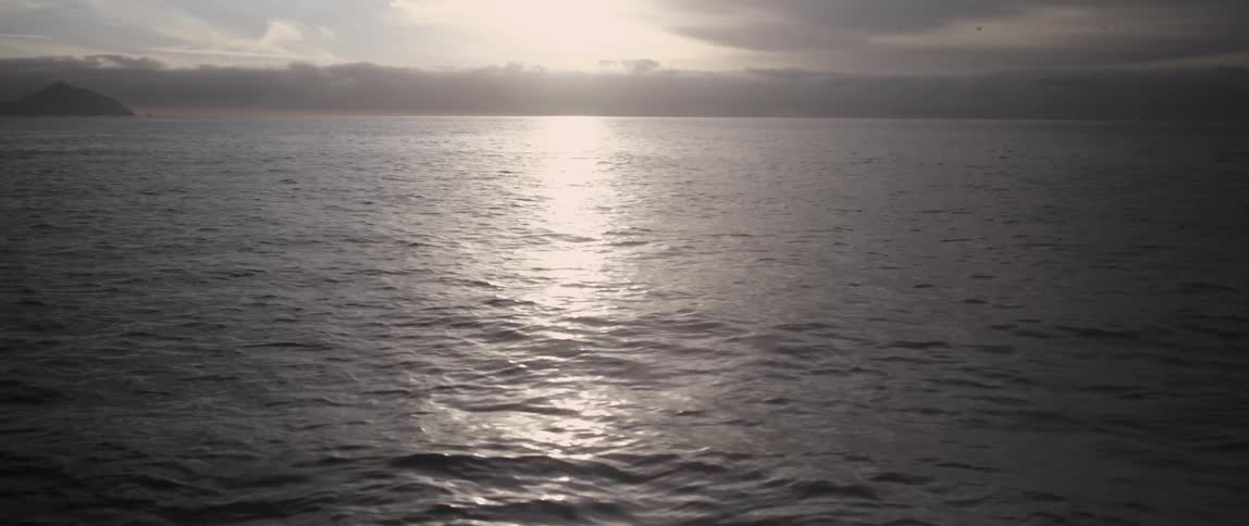The water below is rough at sunset