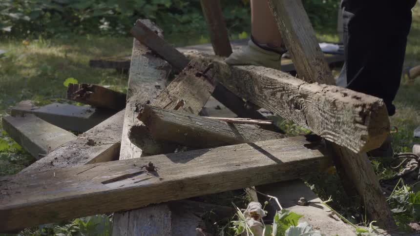 A person stacking wood in a garden