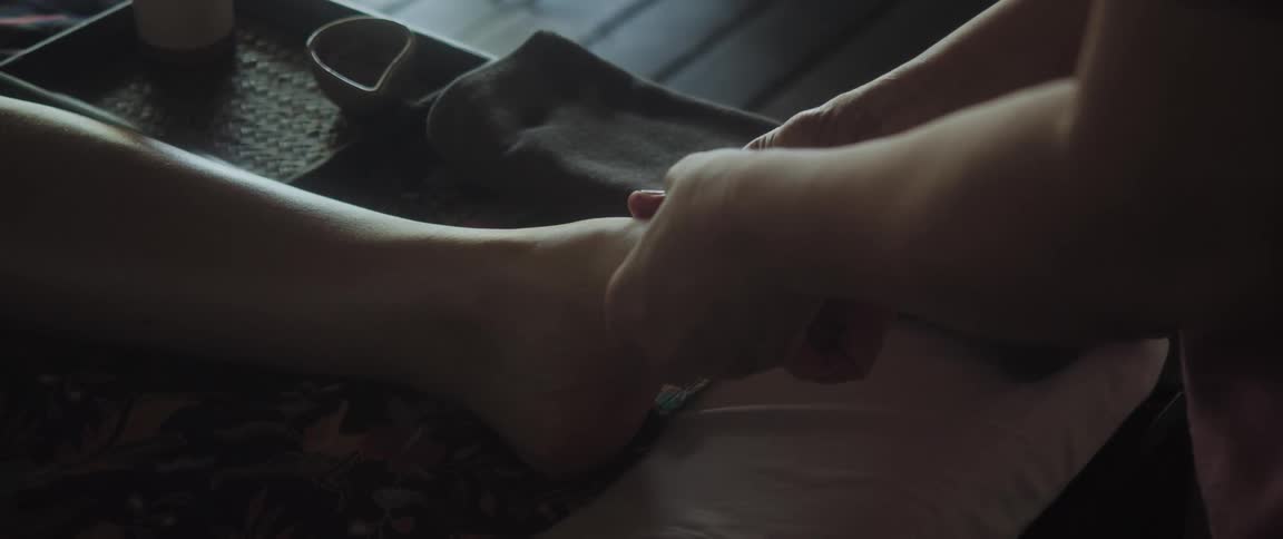 A person is giving someone a foot massage during the daytime
