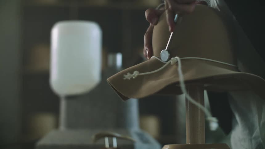 Man working on a sun hat indoor