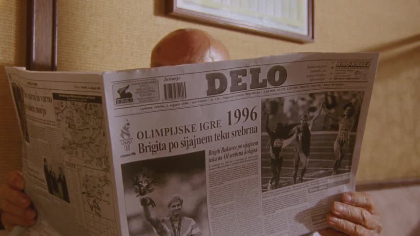 A man is reading an old newspaper at home